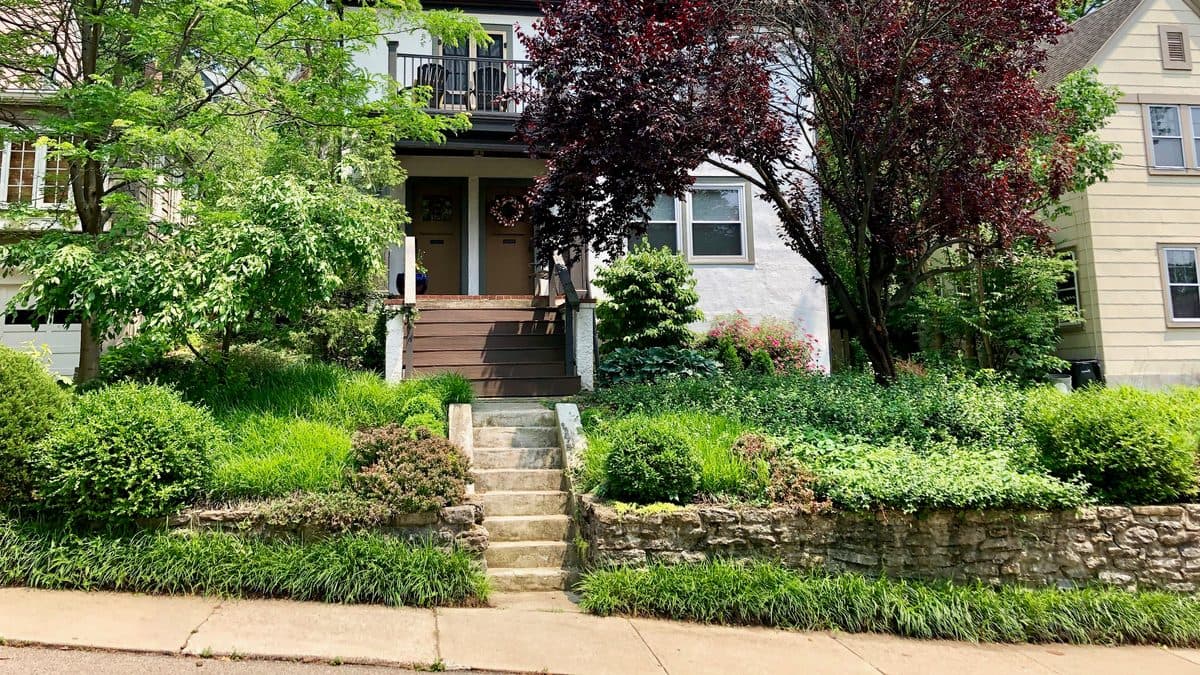A house with a front yard of terraced planting beds and no lawn