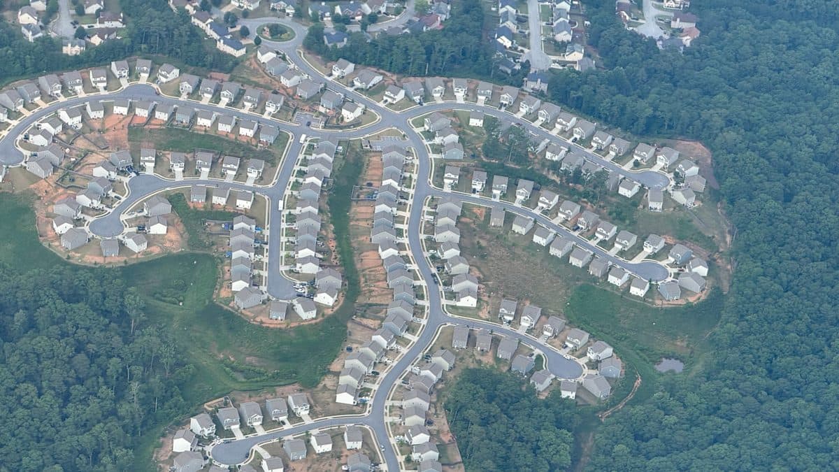 An aerial view of curving subdivision streets lined with single-family houses